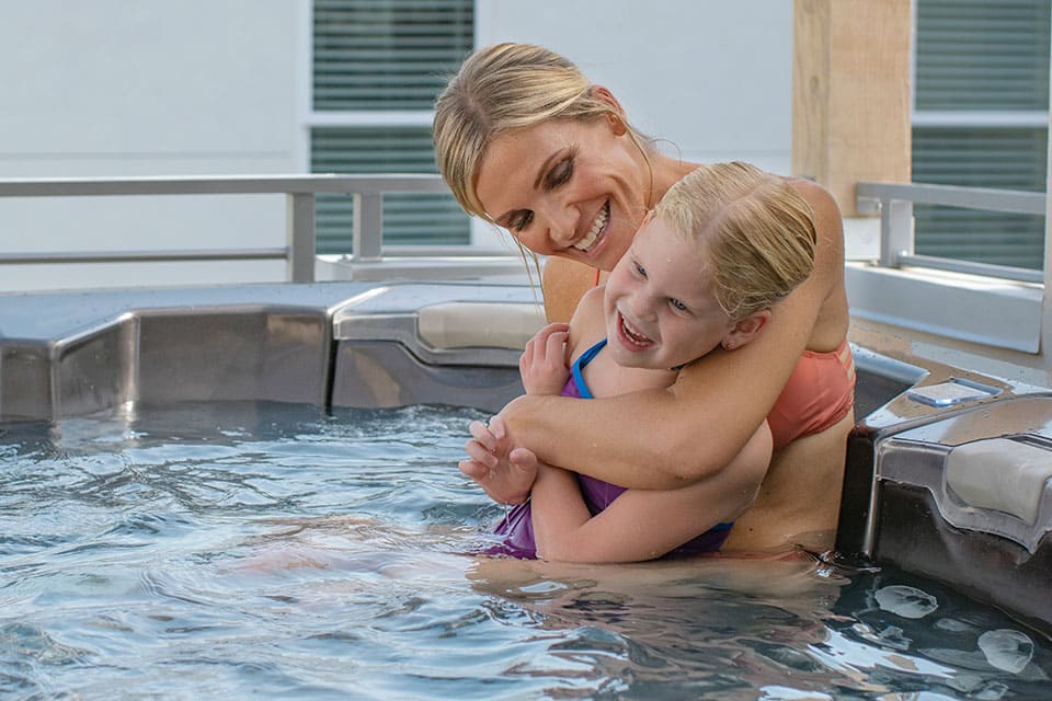 Mother and daughter playing in hot tub